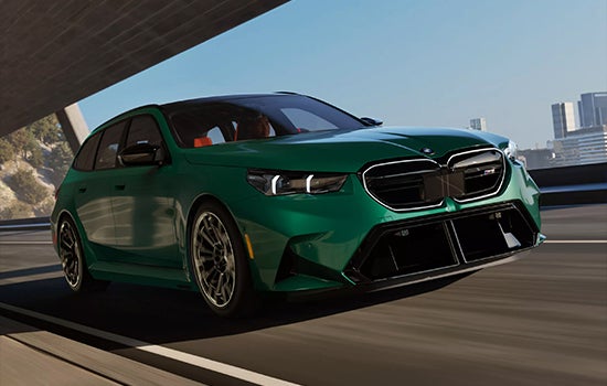 Green BMW M5 Touring driving on a city road. | Zeigler BMW in Kalamazoo MI
